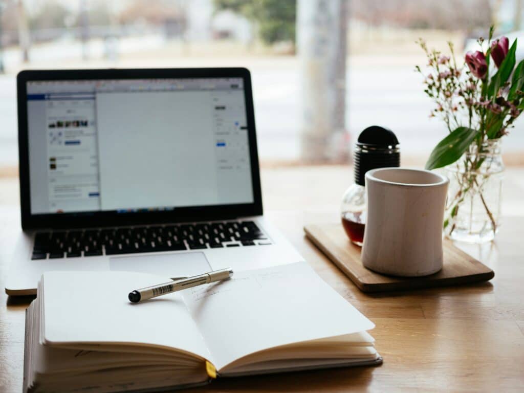 Un ordinateur portable et un bloc note sur une table